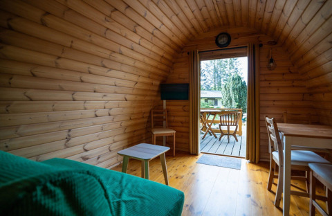 Interior of a cozy pod tiny house at Campsite Roland in the Netherlands, looking out onto the terrace.