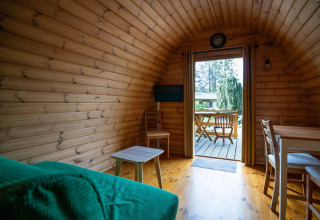 Interior of a cozy pod tiny house at Campsite Roland in the Netherlands, looking out onto the terrace.