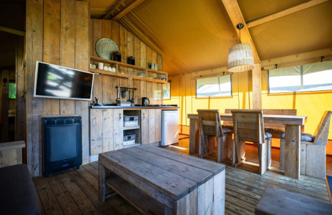 Interiør af en safariteltsuite på Campingplatz Roland i Holland med rustikke træmøbler og hyggelig stemning.