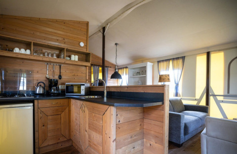 Modernes Holzküchen- und Wohnbereichsbild im Fachwerk-Safarizelt auf Campingplatz Roland, Niederlande.