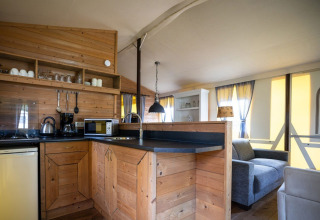 Modernes Holzküchen- und Wohnbereichsbild im Fachwerk-Safarizelt auf Campingplatz Roland, Niederlande.