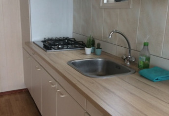 Cuisine moderne du Strand Dishoek 342 avec plan de travail, évier, plaques de cuisson et lumière naturelle.