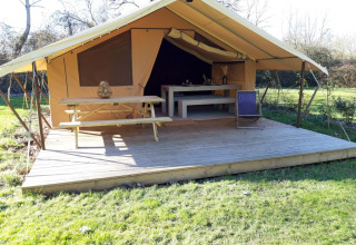 Safari-Zelt auf dem Campingplatz des Tourbières in Frankreich mit Holzterrasse und Sitzgelegenheiten.
