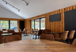 Vista interior de un moderno comedor con paredes de madera en Le Hameau de l'Ourthe, Bélgica Luxemburgo.