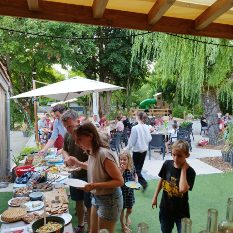 Persone che gustano un buffet all'aperto al Campeggio des Tourbières, Nouvelle-Aquitaine, Francia.