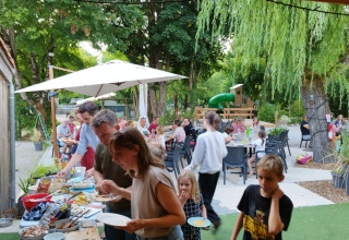 Persone che gustano un buffet all'aperto al Campeggio des Tourbières, Nouvelle-Aquitaine, Francia.