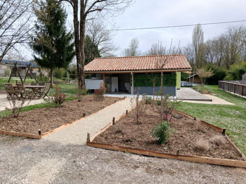 Sentiero di ghiaia tra aiuole al Campsite des Tourbières, parco vacanze in Nouvelle-Aquitaine, Francia.