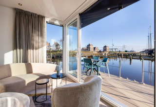 Bright, modern houseboat interior at Marina Lemmer with balcony seating and water views in the Netherlands.