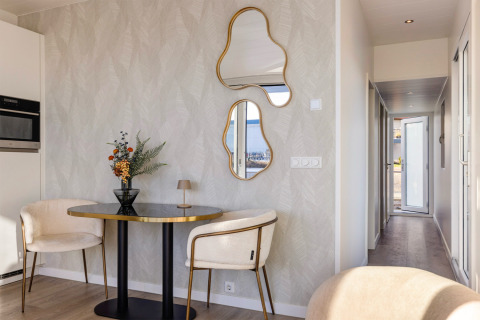 Interno elegante dell’Houseboats Lemmer a Marina Lemmer, con tavolo tondo, sedie moderne e specchi particolari.