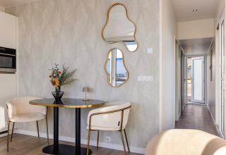 Interno elegante dell’Houseboats Lemmer a Marina Lemmer, con tavolo tondo, sedie moderne e specchi particolari.