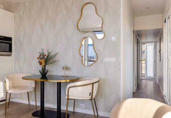 Interno elegante dell’Houseboats Lemmer a Marina Lemmer, con tavolo tondo, sedie moderne e specchi particolari.