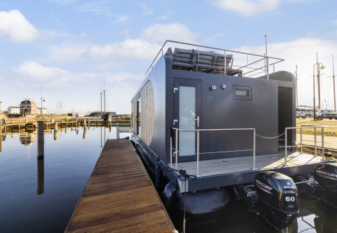 Moderne husbåd Houseboats «Lemmer» fortøjet ved Marina Lemmer i Holland, set fra broen.