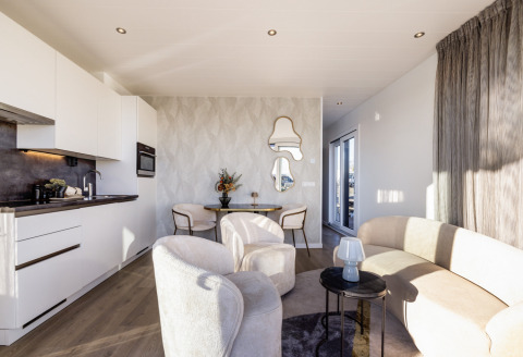 Lyst og moderne interiør i husbåden Lemmer ved Marina Lemmer, med stilfuldt køkken og stueområde.