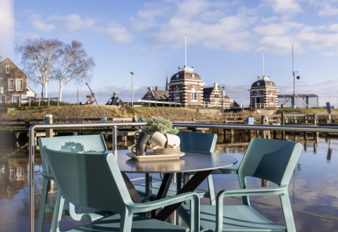 Zona de estar al aire libre en Houseboats «Lemmer» en Marina Lemmer, Países Bajos, frente al canal.