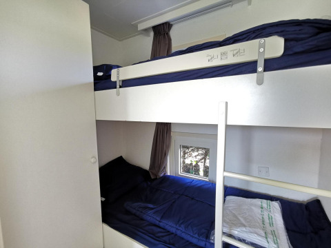 Literas con ropa de cama azul oscuro en una habitación del Chalet Basic en De Woudhoeve, Países Bajos.
