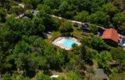 Aerial view of Campsite des Randonneurs in Occitanie, France, featuring a pool surrounded by forest.