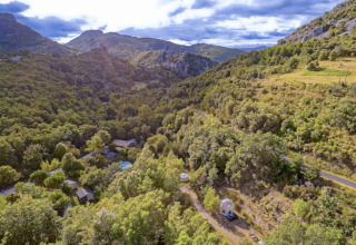 Vista aerea del campeggio «des Randonneurs» in Occitania, Francia, circondato da colline e foreste verdi.