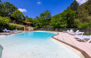 Swimming pool at Campsite des Randonneurs in Occitanie, France, surrounded by greenery and sun loungers.