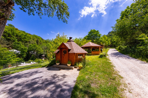 Piccole casette di legno e gazebo al campeggio des Randonneurs, tra il verde e il cielo azzurro in Occitanie.