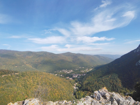 Vista di colline verdi e una valle vicino a Fenouillet, Occitania, Francia, sotto un cielo azzurro con nuvole.