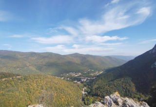 Vista di colline verdi e una valle vicino a Fenouillet, Occitania, Francia, sotto un cielo azzurro con nuvole.