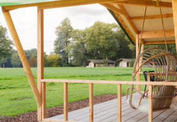 Blick von der Holzterrasse der Luxe Lodge incl oven bei Landrijk de Reesprong in den Niederlanden mit Wiesen.