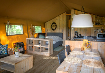 Indvendig udsigt af luksus safari telt på Landrijk de Reesprong i Holland med træmøbler og køkken.
