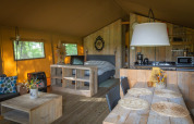 Interior of a luxury safari tent at Landrijk de Reesprong in the Netherlands, featuring wood furniture.