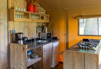 Rustikale Küche in einem luxuriösen Safarizelt bei Landrijk de Reesprong, Niederlande, mit Holz und Gerätschaften.