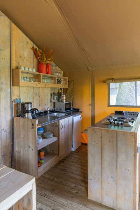 Cucina rustica in una tenda safari di lusso a Landrijk de Reesprong nei Paesi Bassi, con arredi in legno chiaro.