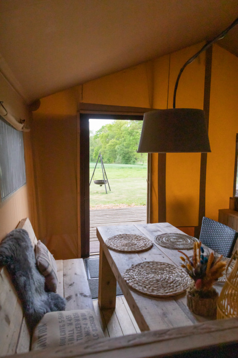 Interior view from luxury safari tent at Landrijk de Reesprong, Netherlands, table with placemats.