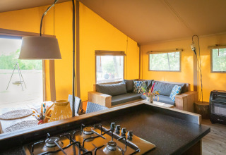 Interieur van een luxueuze safaritent bij Landrijk de Reesprong in Nederland met keuken en zithoek.