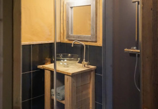 Bagno di una tenda safari di lusso presso Landrijk de Reesprong, Paesi Bassi, con lavabo in vetro.