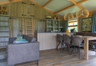 Interno moderno della Luxe lodge a Landrijk de Reesprong nei Paesi Bassi con mobili in legno e atmosfera accogliente.