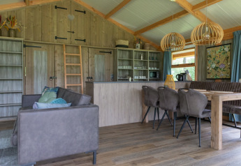 Modernes Interieur der Luxe Lodge bei Landrijk de Reesprong in den Niederlanden mit Holzmöbeln und gemütlichem Ambiente.