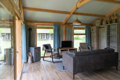 Gemütliches Wohnzimmer einer Luxe Lodge bei Landrijk de Reesprong mit moderner Einrichtung und Ausblick.