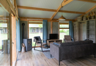 Gemütliches Wohnzimmer einer Luxe Lodge bei Landrijk de Reesprong mit moderner Einrichtung und Ausblick.