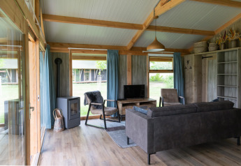 Gemütliches Wohnzimmer einer Luxe Lodge bei Landrijk de Reesprong mit moderner Einrichtung und Ausblick.