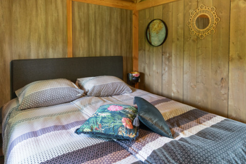 Schlafzimmer der Luxe Lodge im Landrijk de Reesprong, Niederlande, mit Doppelbett und moderner Einrichtung.