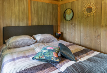 Camera da letto nella Luxe lodge a Landrijk de Reesprong, Paesi Bassi, con letto matrimoniale e arredo accogliente.