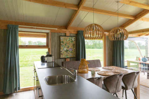 Vista interna della lodge Luxe a Landrijk de Reesprong, Paesi Bassi, con moderno arredamento in legno.
