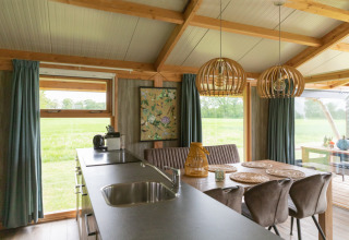 Vista interna della lodge Luxe a Landrijk de Reesprong, Paesi Bassi, con moderno arredamento in legno.