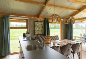 Vista interna della lodge Luxe a Landrijk de Reesprong, Paesi Bassi, con moderno arredamento in legno.