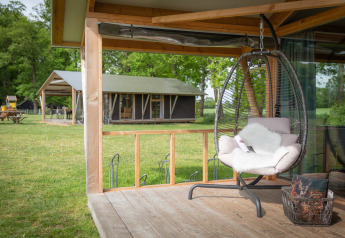 Udendørs opholdsområde med hængestol på terrassen ved Luxe lodge, Landrijk de Reesprong, Holland.