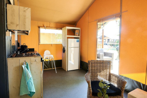 Interieur van safaritent Glamfield Lodge I bij Wilsumer Berge, Duitsland, met keuken en koelkast.