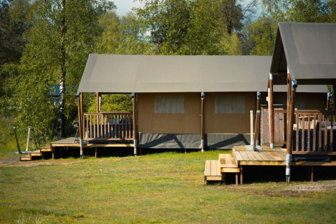 Safari tent Glamfield Lodge I bij Wilsumer Berge in Duitsland, met houten terrassen in groene natuur.