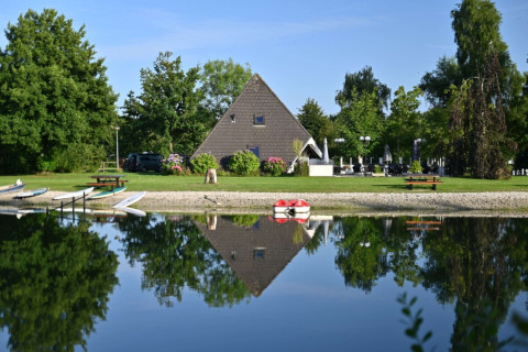 Riflesso di una baita a forma di A nel lago presso il campeggio Hunze Bulten, Drenthe, Paesi Bassi.