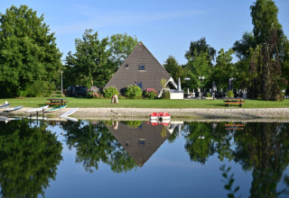 Reflet d'un chalet en A dans le lac paisible au camping Hunze Bulten, un parc de vacances à Drenthe.
