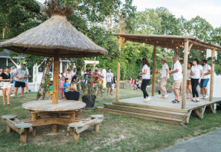 Des familles participent à un événement en plein air au Camping Le Savoy, avec danse sur scène en Auvergne.