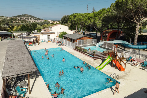 Buitenzwembad met glijbaan en ligstoelen bij Flower Camping Provence Vallée in Provence-Alpes-Côte d’Azur, Frankrijk.
